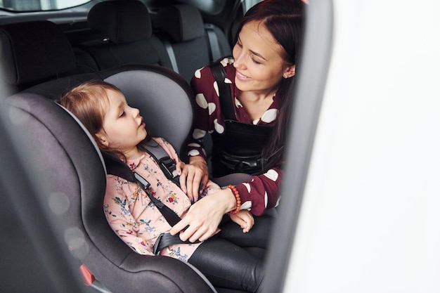 Mother with her daughter inside of modern automobile together