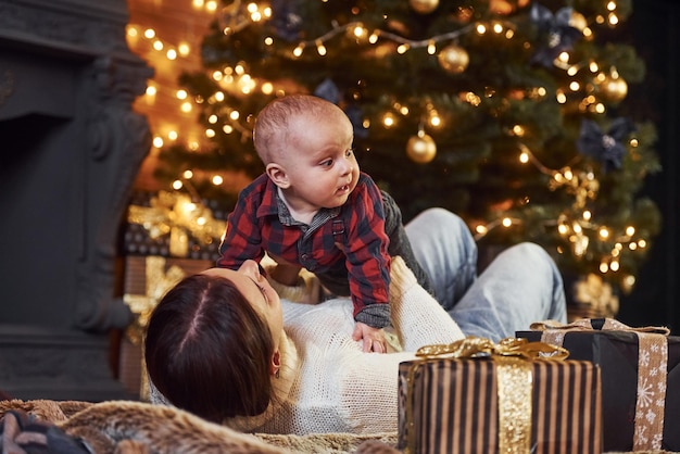 Mother with her little son celebrating new year and christmas holidays indoors.