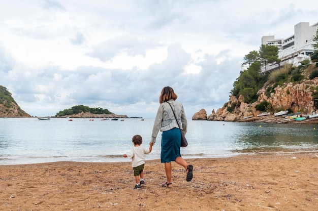 A mother with her son on the beach in the port of San Miquel on the island of Ibiza Balearic Islands