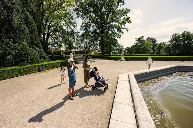 Mother with kids near fountain of Slavkov Castle also known as Austerlitz Castle is a Baroque palace in Slavkov u Brna Czech Republic