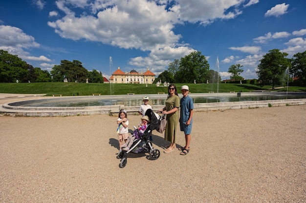 Mother with kids near fountain of Slavkov Castle also known as Austerlitz Castle is a Baroque palace in Slavkov u Brna Czech Republic