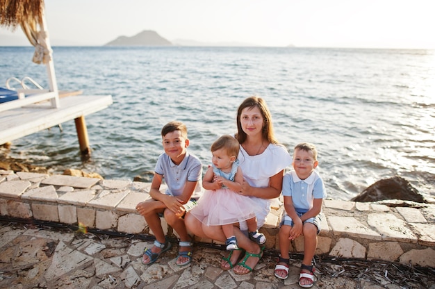 Mother with three kids on Turkey resort against Mediterranean sea.