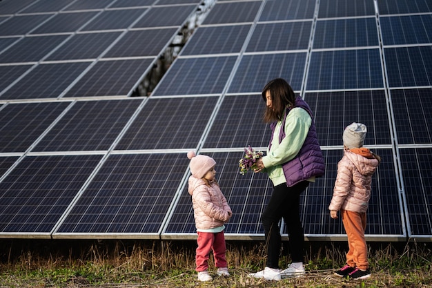 Mother with two daughters on the background of solar panels Eco energy