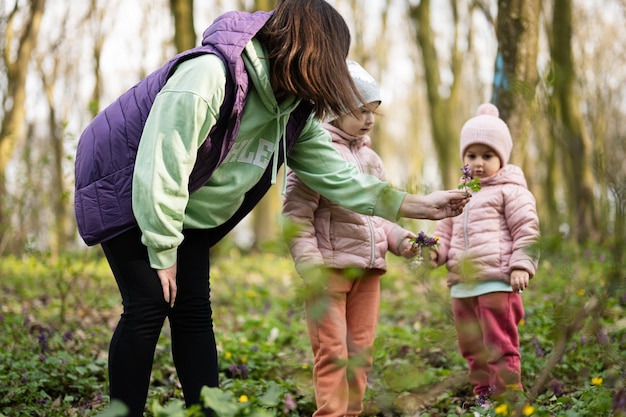 Mother with two daughters on forest Outdoor spring leisure concept