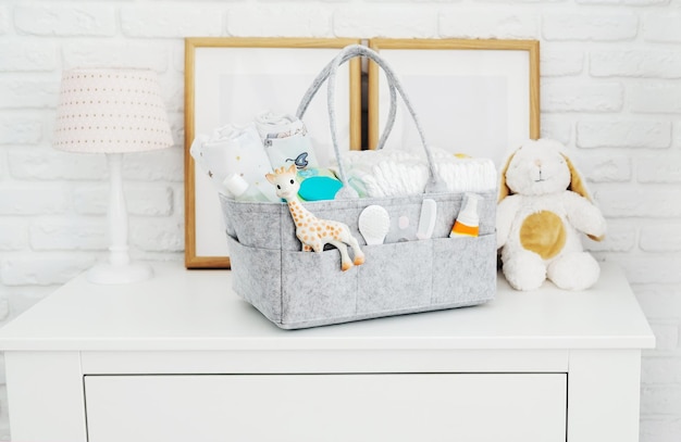 Photo mothers bag with toy diapers and accessories on white background