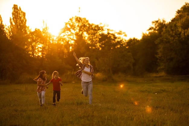 mothers and daughters in a field at sunset with an kite