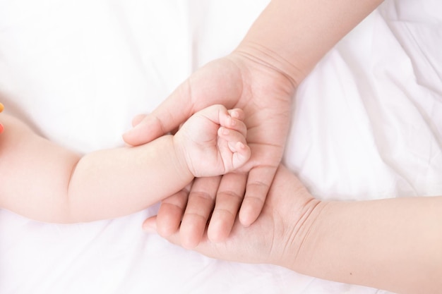 Mothers hand holding newborn babys barefoot