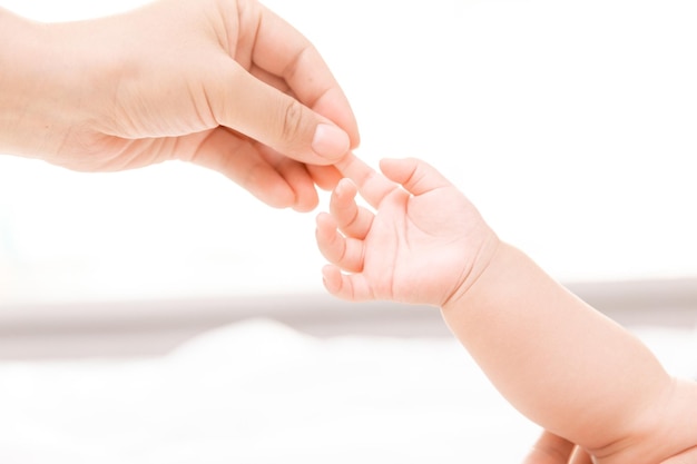 Mothers hand holding newborn babys barefoot