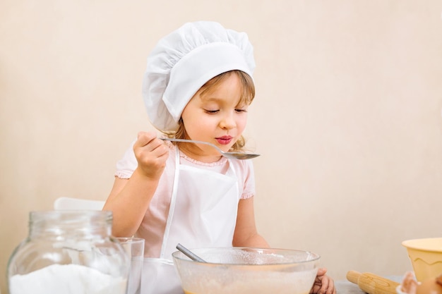 A mothers helper takes a sample while preparing a pie and performs a stepbystep recipe on a tablet