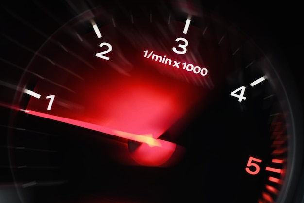 Motion blur of a car instrument panel dashboard odometer with red illuminated displayCar speedometer High speed car speedometer and motion blur at night