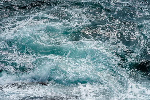 Motion of sea water surface with stone, Blue water splashing