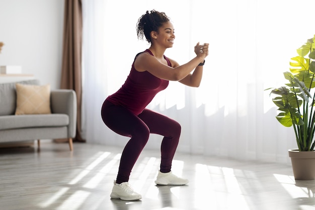 Motivated african american woman exercising at home