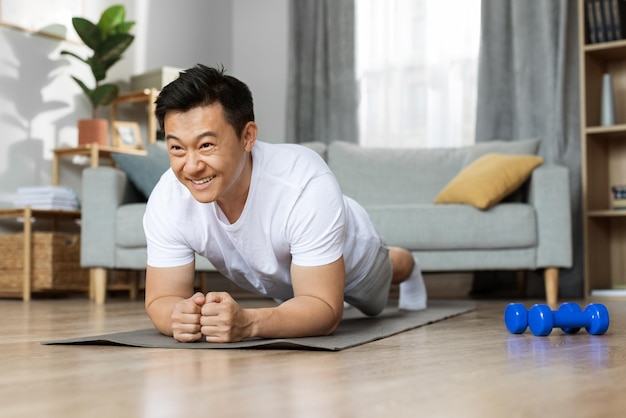 Motivated asian man having workout at home