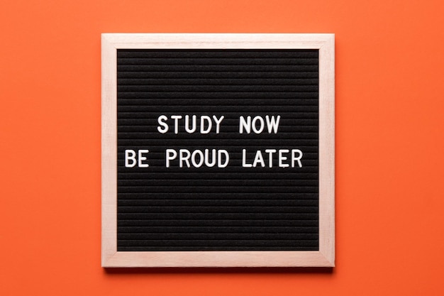 Motivational quote on black letter board on orange background Study now be proud later Inspirational quote of the day