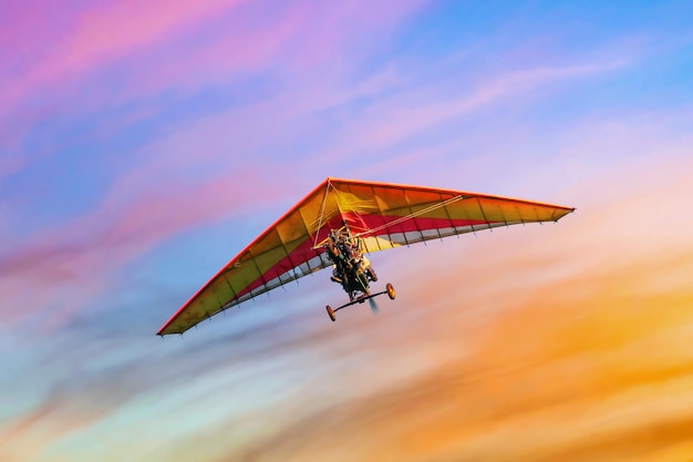 Photo moto hang glider in flight against the background of colorful sunset sky