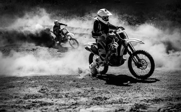 Motocross racer accelerating in dust track Black and white high contrast photo