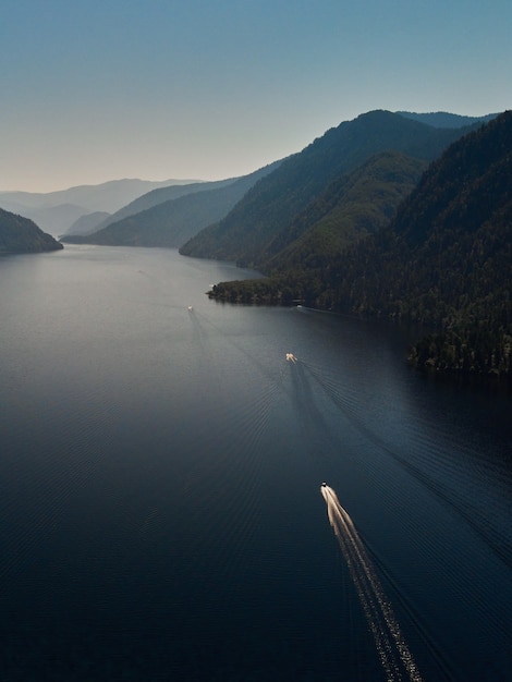 Motor boat moored to the shore of a mountain lake. Russia, Altai Republic, Ulagansky district, Lake Teletskoye, tract Cordon Chiri