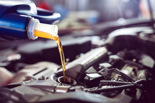 Motor oil pouring to car engine.