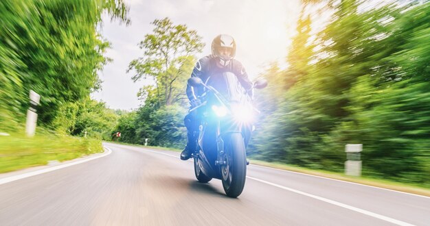 Motorbike on the forest road riding having fun driving the empty road on a motorcycle tour journey