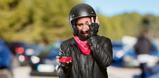 Photo motorbike rider holding a red car model