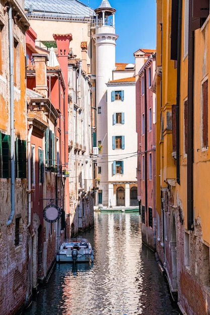 Motorboat on canal water amidst historic residential buildings