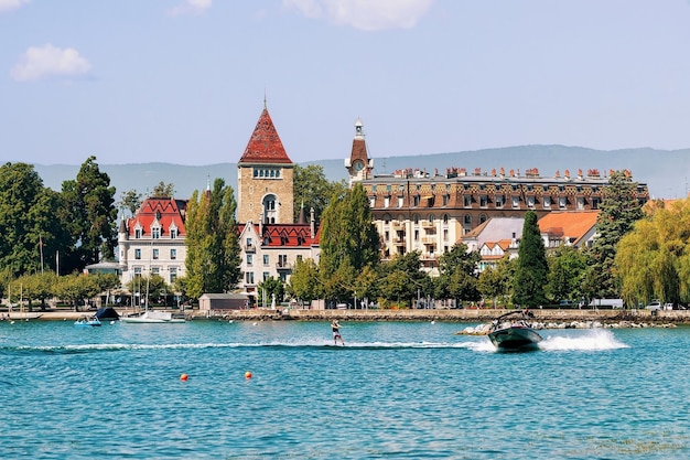 Motorboat with man wakeboarding at Lake Geneva near Chateau Ouchy in Lausanne, Switzerland.