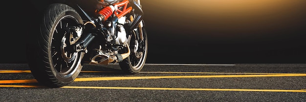 Motorcycle parked alone on a asphalt road in the night timeMotorbike panoramic banner concept