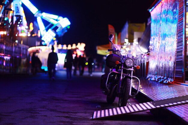 Photo motorcycle parked at illuminated amusement park