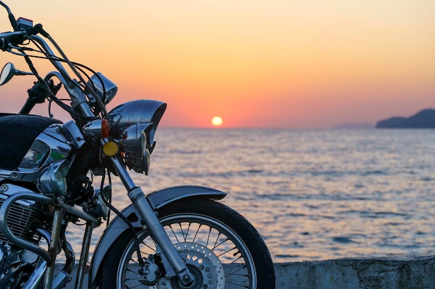 Motorcycle on the sea pier during a beautiful sea sunset Travel adventure vacation concept