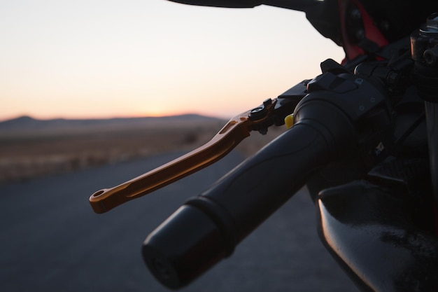 Motorcycle stands on the road at sunset