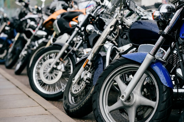 Motorcycle wheel with disk brakes system and metal spokes. Closeup detailed photo of motorbike forks and tire. Different parts of two-wheeled vehicle.  Transportation.