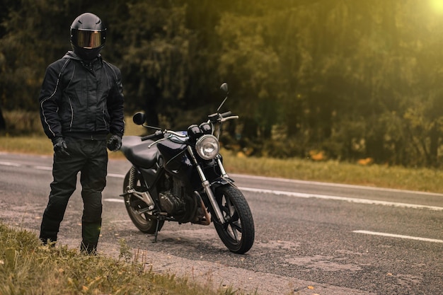 motorcyclist in a motorcycle jacketon a custom motorcycle cafe racer.