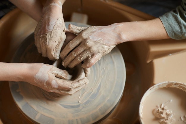 Moulding clay together on pottery wheel