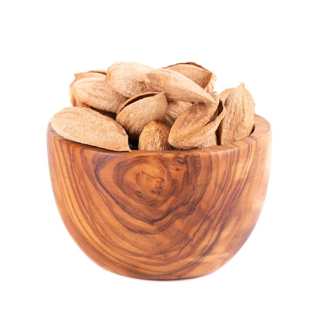 Mountain almonds in wooden bowl isolated on white background Uzbek wild almonds