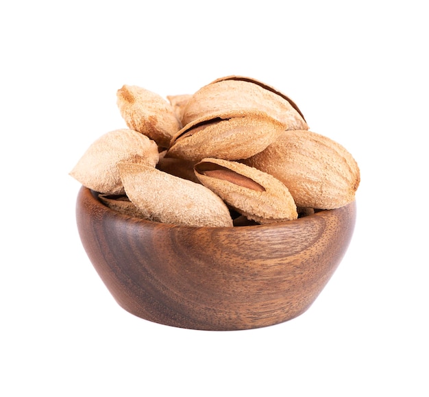 Mountain almonds in wooden bowl isolated on white background Uzbek wild almonds