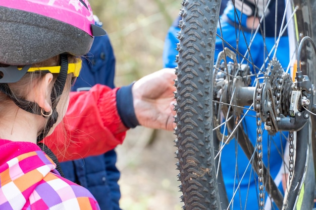 Mountain bike in the forest for crosscountry competitions The rear wheel and tire of a bicycle are closeup against the background of a dirt road Bicycle repair Active recreation in nature