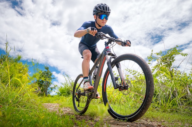 Mountain bikers ride MTB, mountain bike downhill to the extreme.  Asian man rides MTB, mountain bike in the wild to extremes. Extreme Sport and MTB, mountain bike Concept.