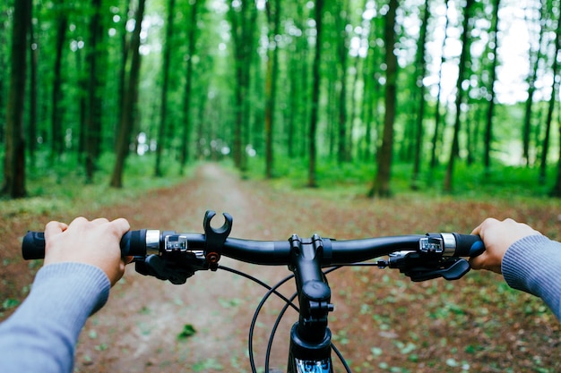 Mountain biking down hill descending fast on bicycle. View from bikers eyes.