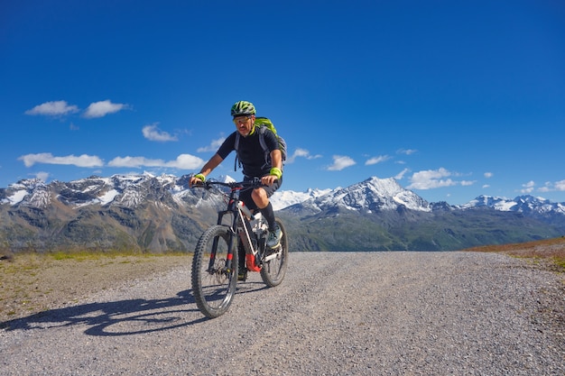 Mountain biking in the high mountains on a dirt road