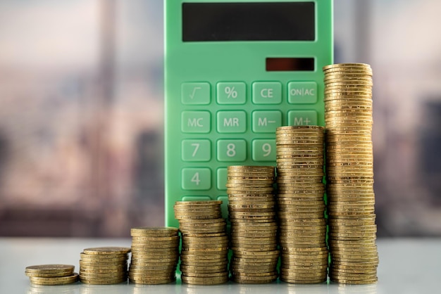 Mountain of coins on a glass table with a calculator