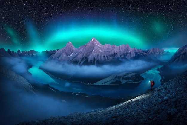 a mountain is lit up by a green aurora