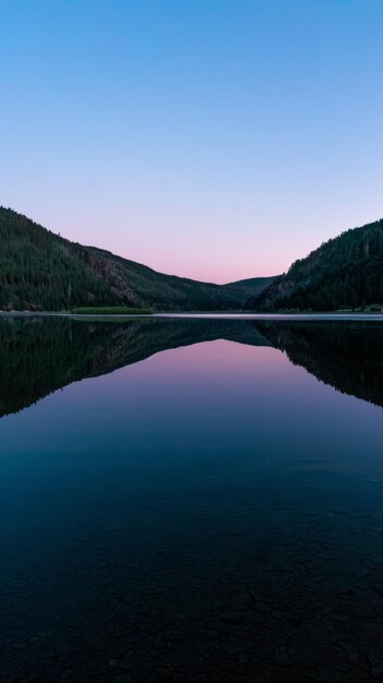 Mountain lake its surface reflecting the subtle colors of dawn background with copyspace