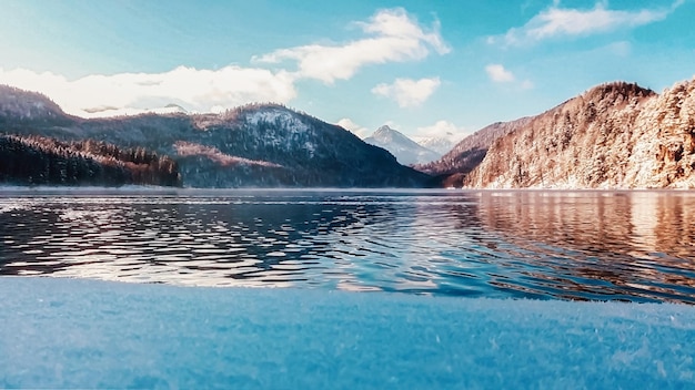 Mountain lake in winter snow and water golden hour light