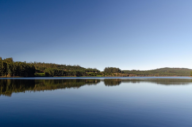 Mountain lake with calm water like a mirror where the trees of the forest are reflected