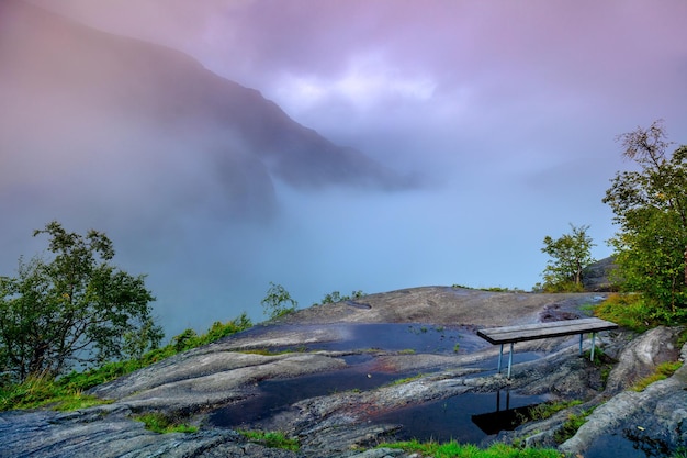 Mountain landscape in early morning with cloudy sky Composition of nature with bench