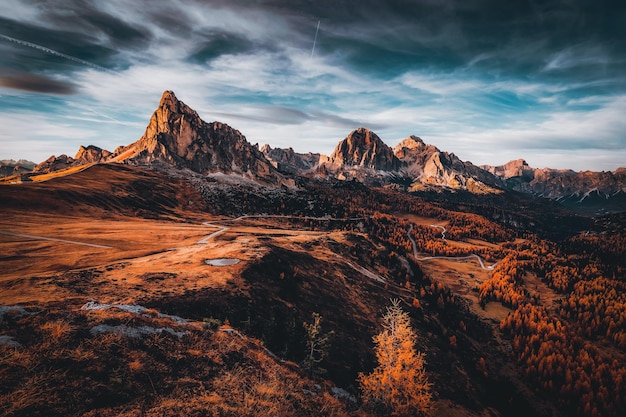 A mountain landscape with a sunset and a cloudy sky