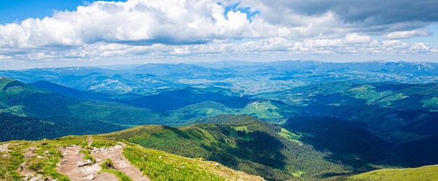 Mountain path Springtime landscape in mountains Mountains ridge high rocky peaks panorama Mountain landscape with hiking trail panorama