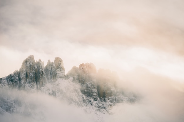 Mountain peaks in the clouds at sunset. Dolomites, Val di Fassa, Italy