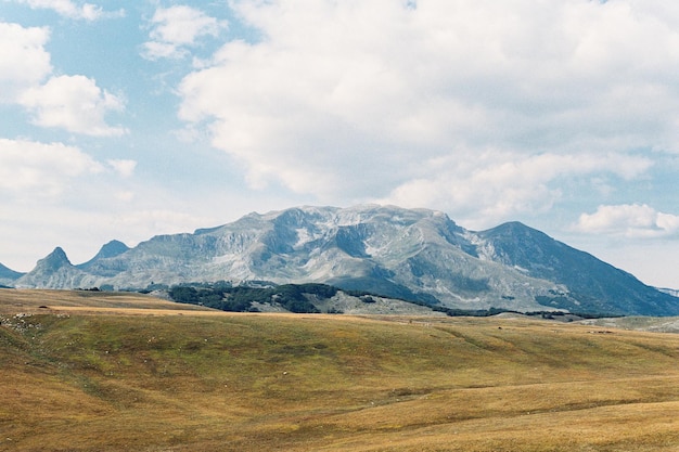 Mountain range rises above a valley against a blue sky. High quality photo