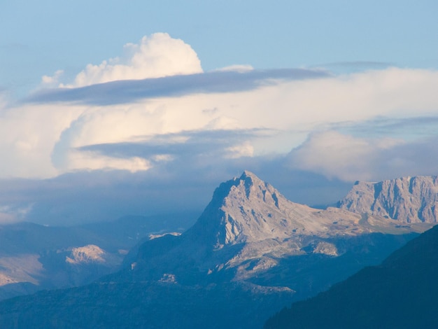 A mountain range with a cloud in the sky